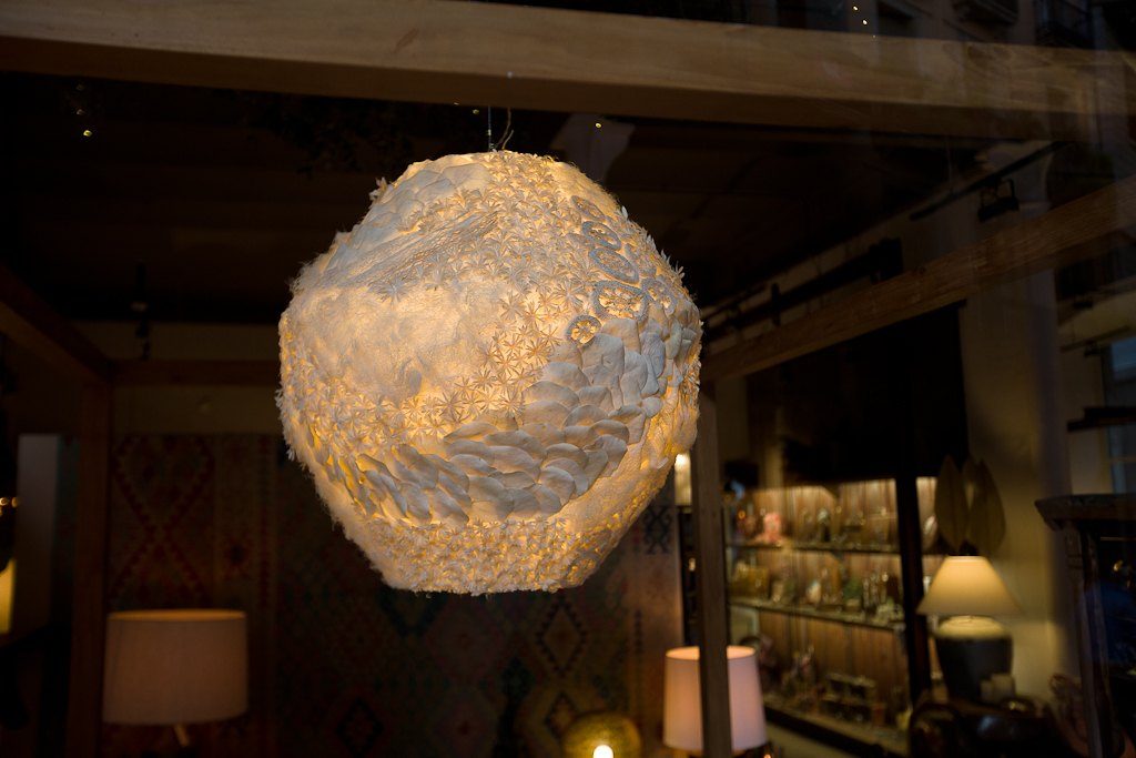 Esfera de papel encendida en un interior en penumbra